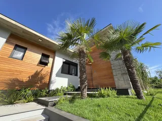 Fachada moderna de uma residência com revestimento de madeira e paredes brancas.