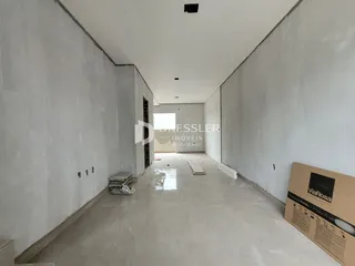 Corredor interno de uma residência com paredes brancas e piso claro.