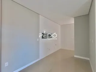 Vista interna de um ambiente com paredes brancas e piso claro.
