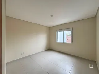 Uma sala com paredes brancas e piso de cerâmica.