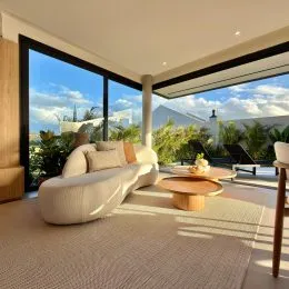 Sala de estar com sofá e vista para o exterior.