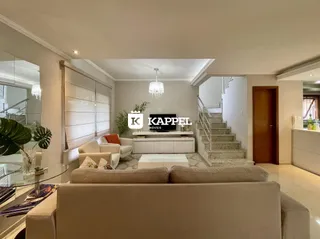 Sala de estar moderna com sofá grande e iluminação de cristal.