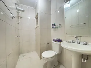 Foto de um banheiro com revestimento cerâmico branco.