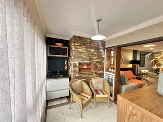 Sala de estar com parede de pedra e móveis de vime.