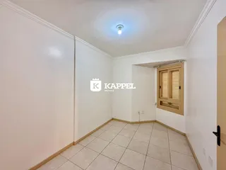 Hall de entrada com piso de cerâmica claro e paredes brancas.