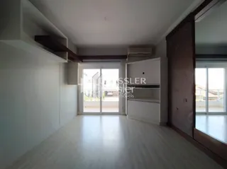 Ambiente interno com piso de madeira clara e porta de vidro.