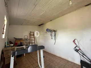 Interior de um cômodo com teto de madeira e piso de cerâmica.