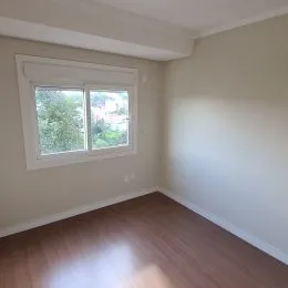 Foto de um cômodo interno com janela e piso de madeira.