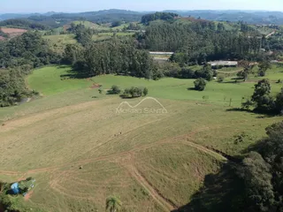 Vista aérea de campos verdes e vegetação em uma paisagem rural.