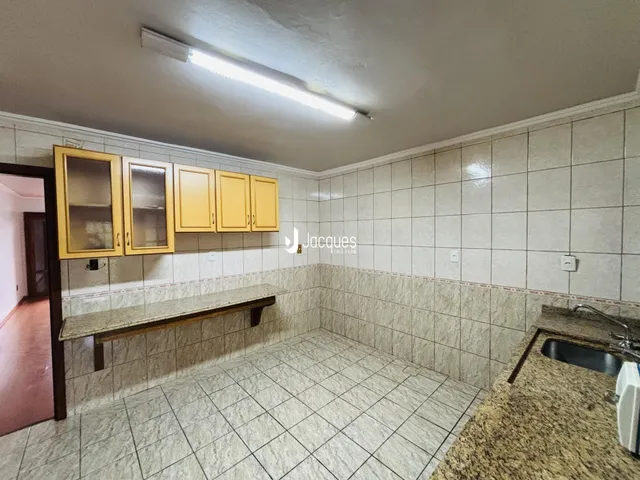 Foto de um banheiro com revestimento cerâmico e armários de madeira.