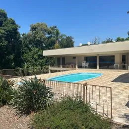 Foto de uma área externa com piscina e paisagismo em uma propriedade.
