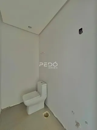 Foto de um banheiro interno com azulejos brancos e piso claro.