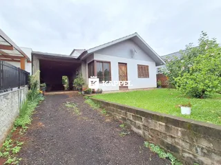 Fachada de uma casa em Lajeado, Brasil, com um pátio gramado e um caminho de terra.