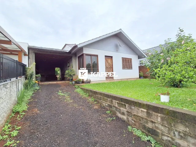 Fachada de uma casa em Lajeado, Brasil, com um pátio gramado e um caminho de terra.
