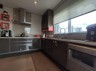 Vista interna de uma cozinha moderna com armários e bancadas.