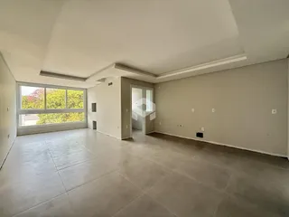 Sala ampla com piso claro e grande janela.