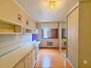 Vista de um corredor com armários embutidos e piso de madeira.