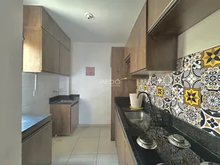 Vista da cozinha com armários de madeira e revestimento decorativo.