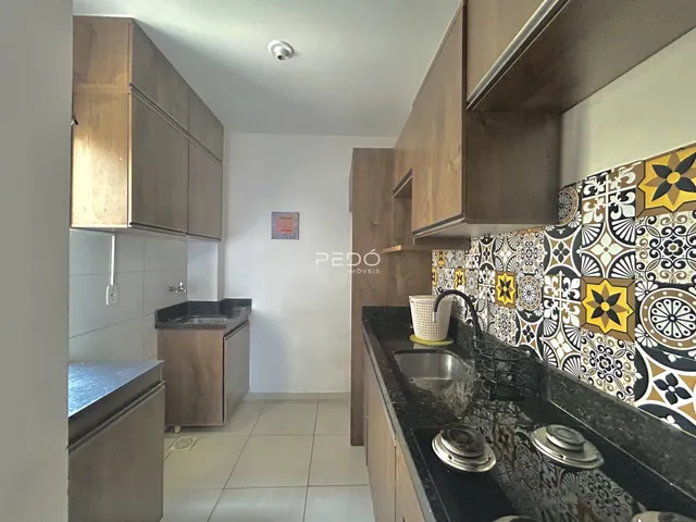 Vista da cozinha com armários de madeira e revestimento decorativo.