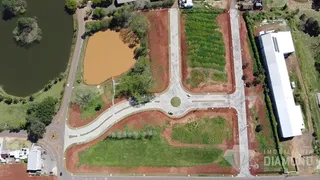 Vista aérea de um terreno com corpo d'água e uma edificação industrial.