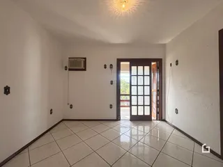 Sala de estar com piso de cerâmica e porta de vidro.