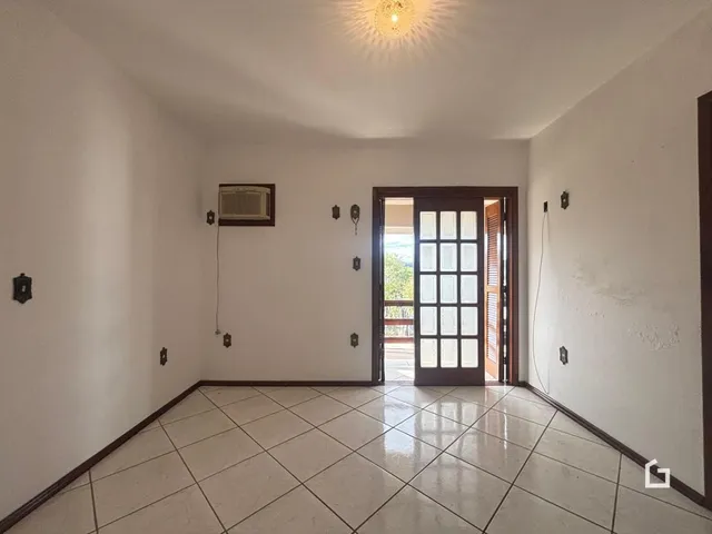 Sala de estar com piso de cerâmica e porta de vidro.