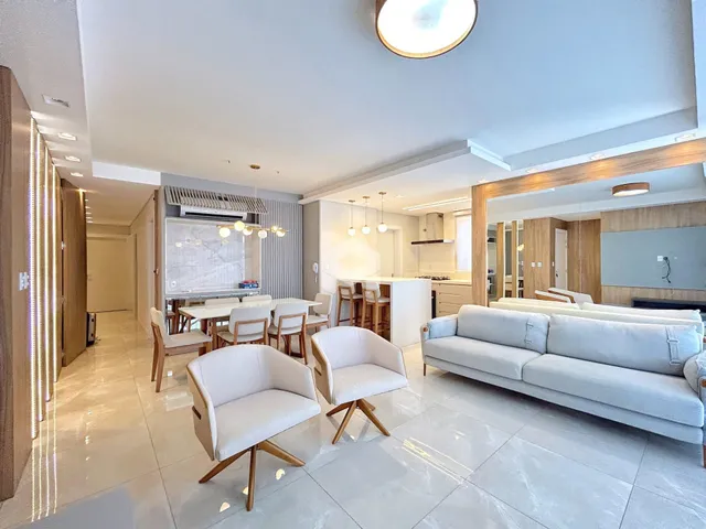 Sala de estar moderna com sofá e poltronas em um apartamento.