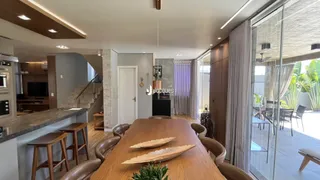 Vista de uma sala de jantar com mesa de madeira e portas de vidro.