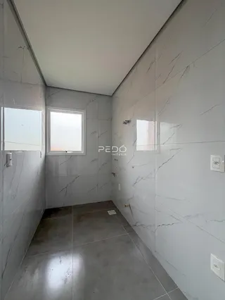 Corredor interno com revestimento em mármore cinza nas paredes e piso.