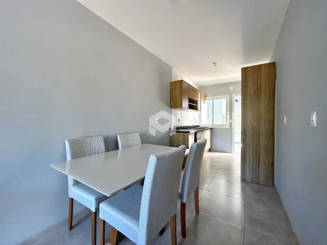 Uma sala de jantar com mesa e cadeiras em um apartamento.