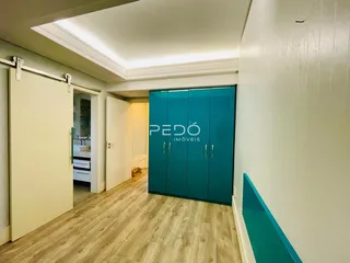 Hall de entrada com piso de madeira e armário azul.