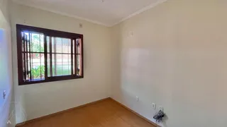 Sala de estar com grande janela e piso de madeira clara.