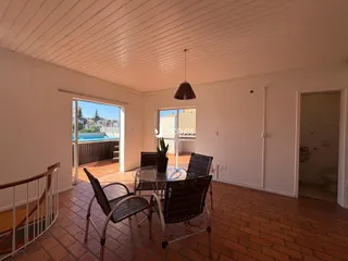 Ambiente interno com piso de tijolo e vista para a área externa.