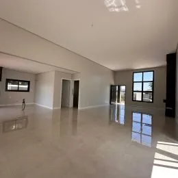 Ambiente interno amplo com piso claro e paredes brancas.