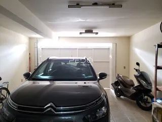 Imagem de um interior com um carro e uma motocicleta estacionados.