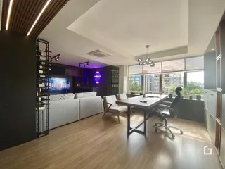 Sala de estar e jantar com piso de madeira e vista para a cidade.