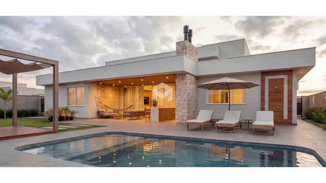 Fachada de casa moderna com piscina e área gourmet em Lajeado.