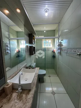 A foto mostra um banheiro com revestimento cerâmico.