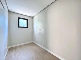 Ambiente interno com paredes claras e piso de madeira.
