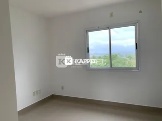 Ambiente interno de uma sala com grande janela que oferece vista para a paisagem.