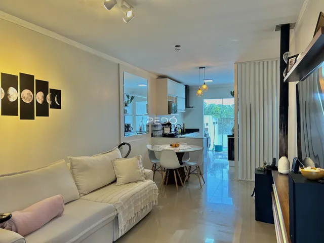 Sala de estar com sofá e mesa de jantar em um apartamento no Brasil.