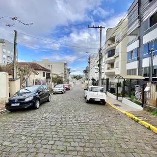 Vista de uma rua pavimentada com carros estacionados em Lajeado, Brasil.