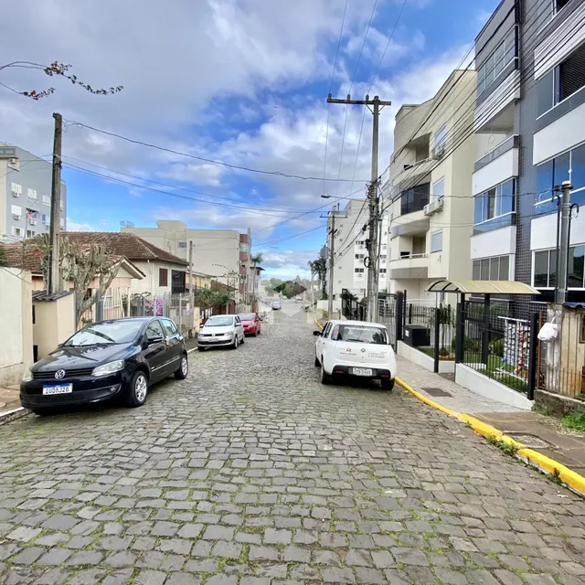 Vista de uma rua pavimentada com carros estacionados em Lajeado, Brasil.