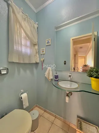 Foto de um banheiro com piso de cerâmica e bancada de vidro.