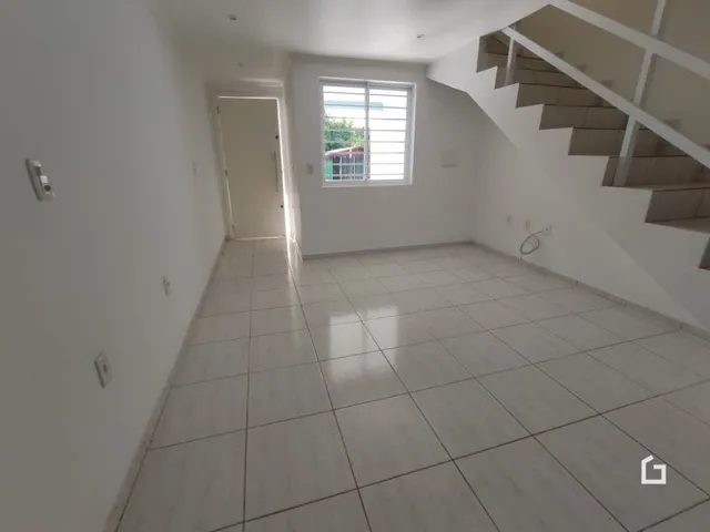 Foto de um ambiente interno com piso de cerâmica e escadaria.