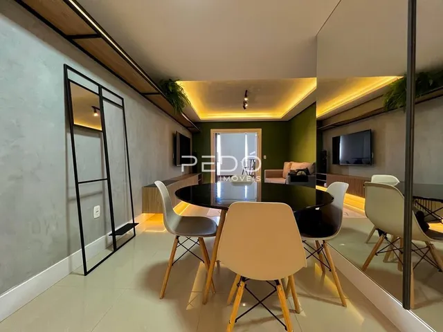 Sala de estar com pé direito alto e vigas de madeira em um imóvel no Brasil.