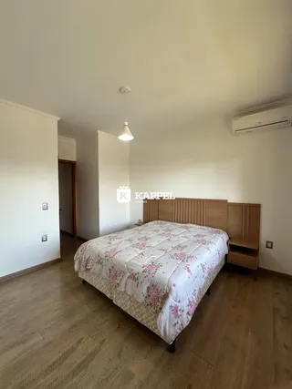 Este é um quarto com cama de madeira e piso de madeira clara.