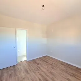 Foto de um ambiente interno com piso de madeira clara.