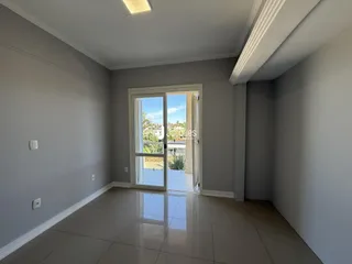 Interior de uma sala com piso de cerâmica e porta de vidro.