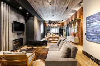 Sala de estar com sofá, televisão e lareira em ambiente moderno.